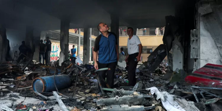 Palestinians inspect the site of an Israeli strike on a school sheltering displaced people, amid Israel-Hamas conflict, in Deir Al-Balah, in the central Gaza Strip, October 6, 2024. REUTERS/Ramadan Abed